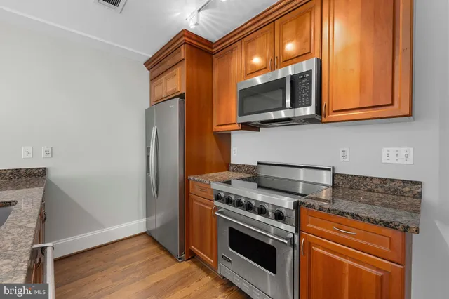 a kitchen with stainless steel appliances granite countertop a stove microwave and refrigerator