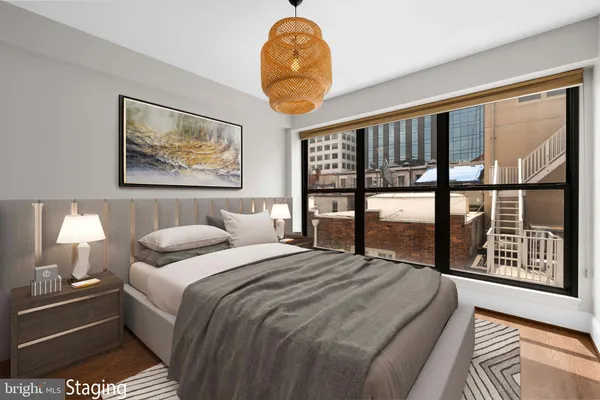 a bedroom with a bed and a large window