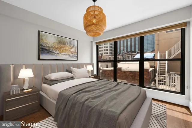 a bedroom with a bed and a large window