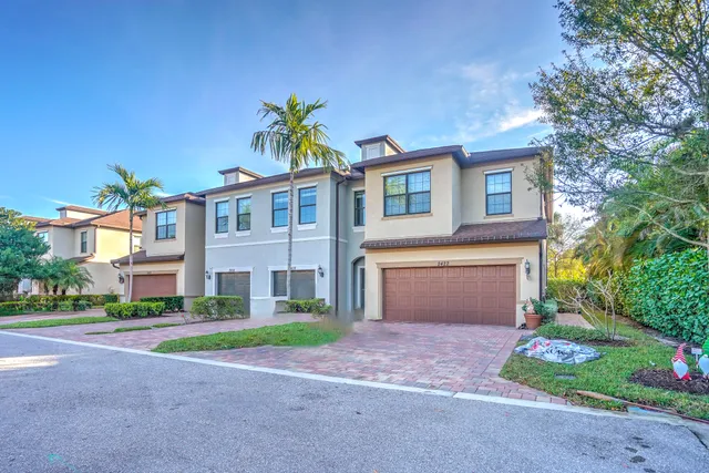 a front view of a house with a yard and a garage