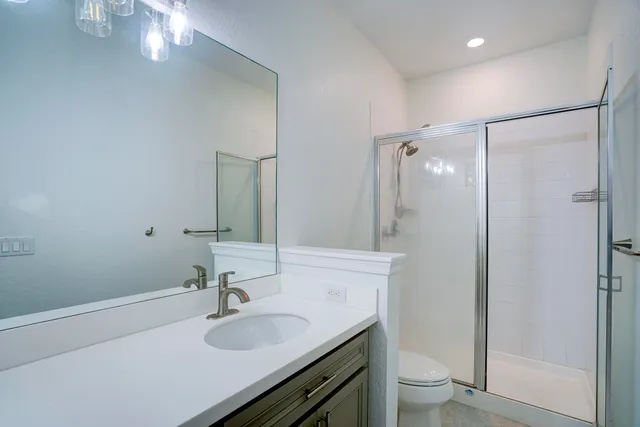 a bathroom with a granite countertop sink toilet and shower