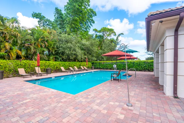 a view of pool with a table and chairs under an umbrella