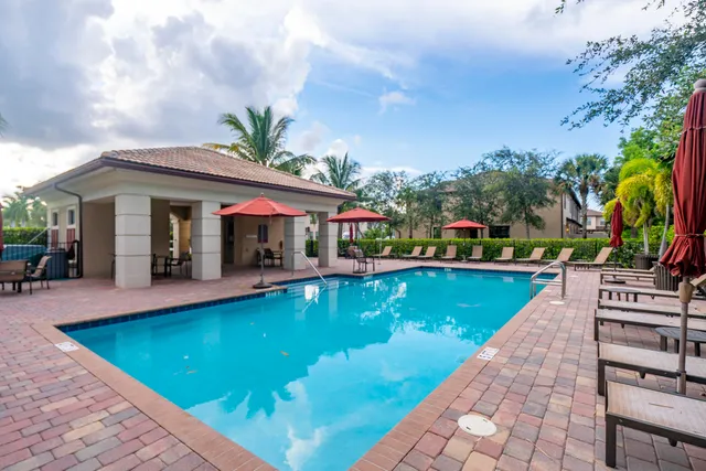 a view of a house with swimming pool and sitting area
