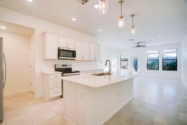 a kitchen with a sink a counter top space stainless steel appliances and cabinets