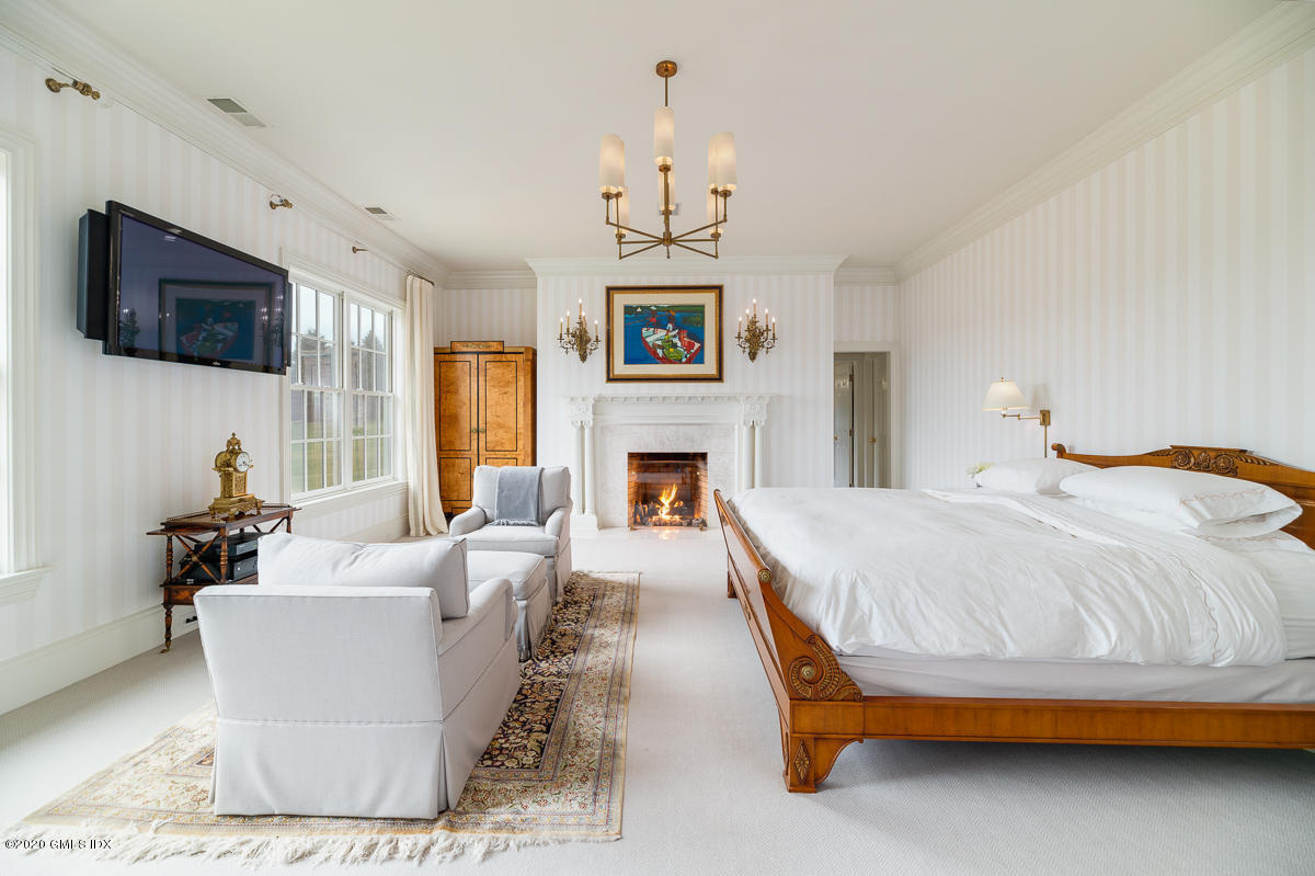 7 Chieftans Road Greenwich, CT 06831 - Photo 17 of 37 a spacious bedroom with a bed and a flat screen tv