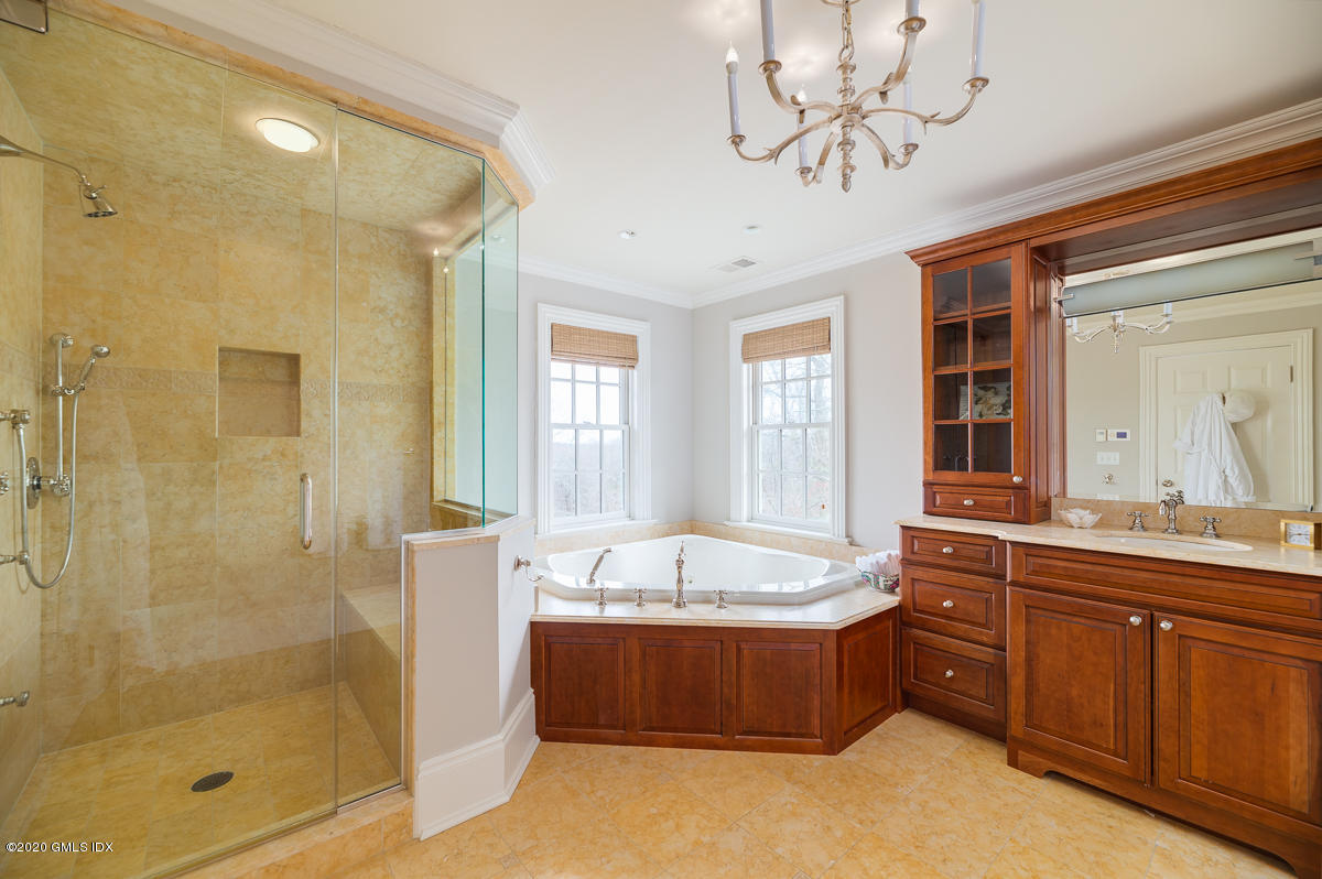 7 Chieftans Road Greenwich, CT 06831 - Photo 18 of 37 a spacious bathroom with a tub sink shower and mirror