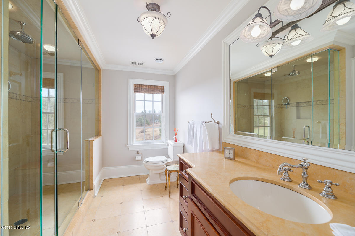 7 Chieftans Road Greenwich, CT 06831 - Photo 19 of 37 a spacious bathroom with a sink a large mirror and a shower