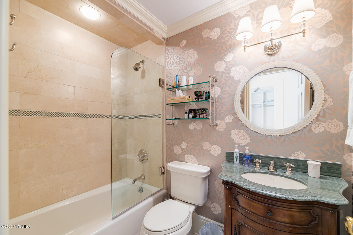 7 Chieftans Road Greenwich, CT 06831 - Photo 21 of 37 a bathroom with a granite countertop toilet sink mirror vanity and shower