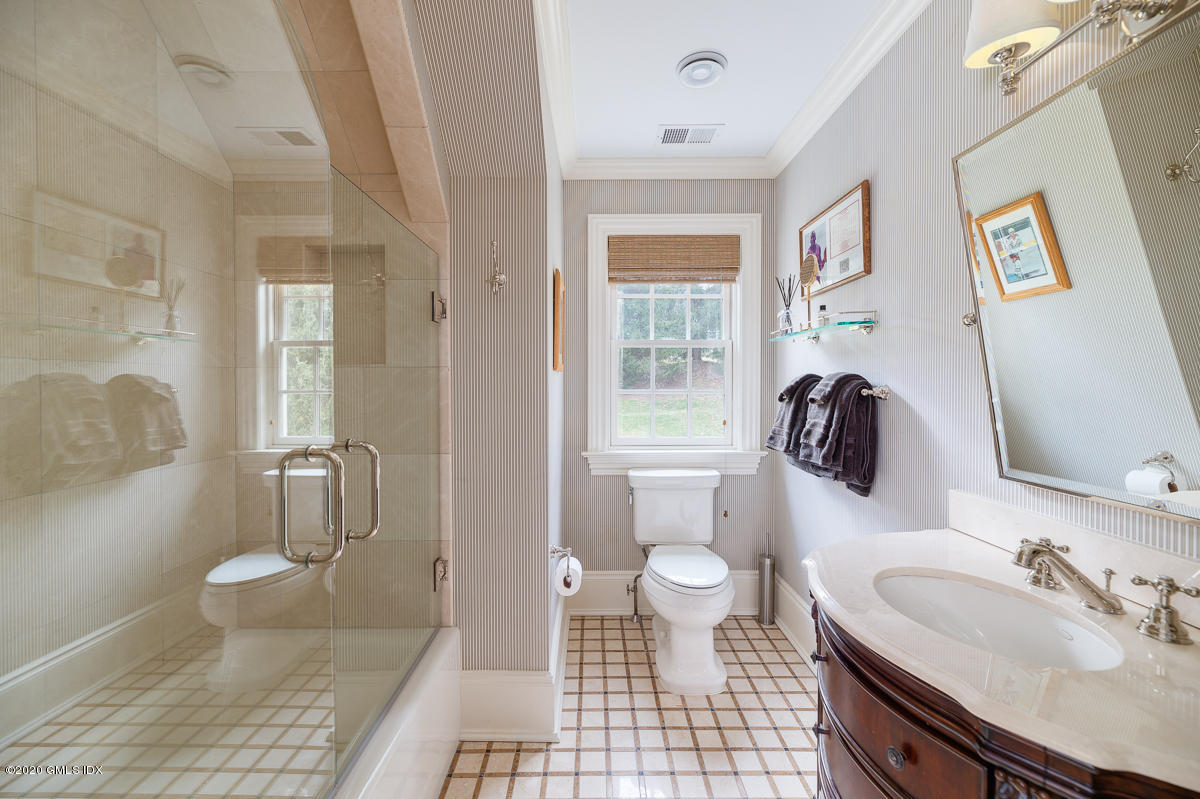 7 Chieftans Road Greenwich, CT 06831 - Photo 23 of 37 a bathroom with a sink toilet a mirror and shower