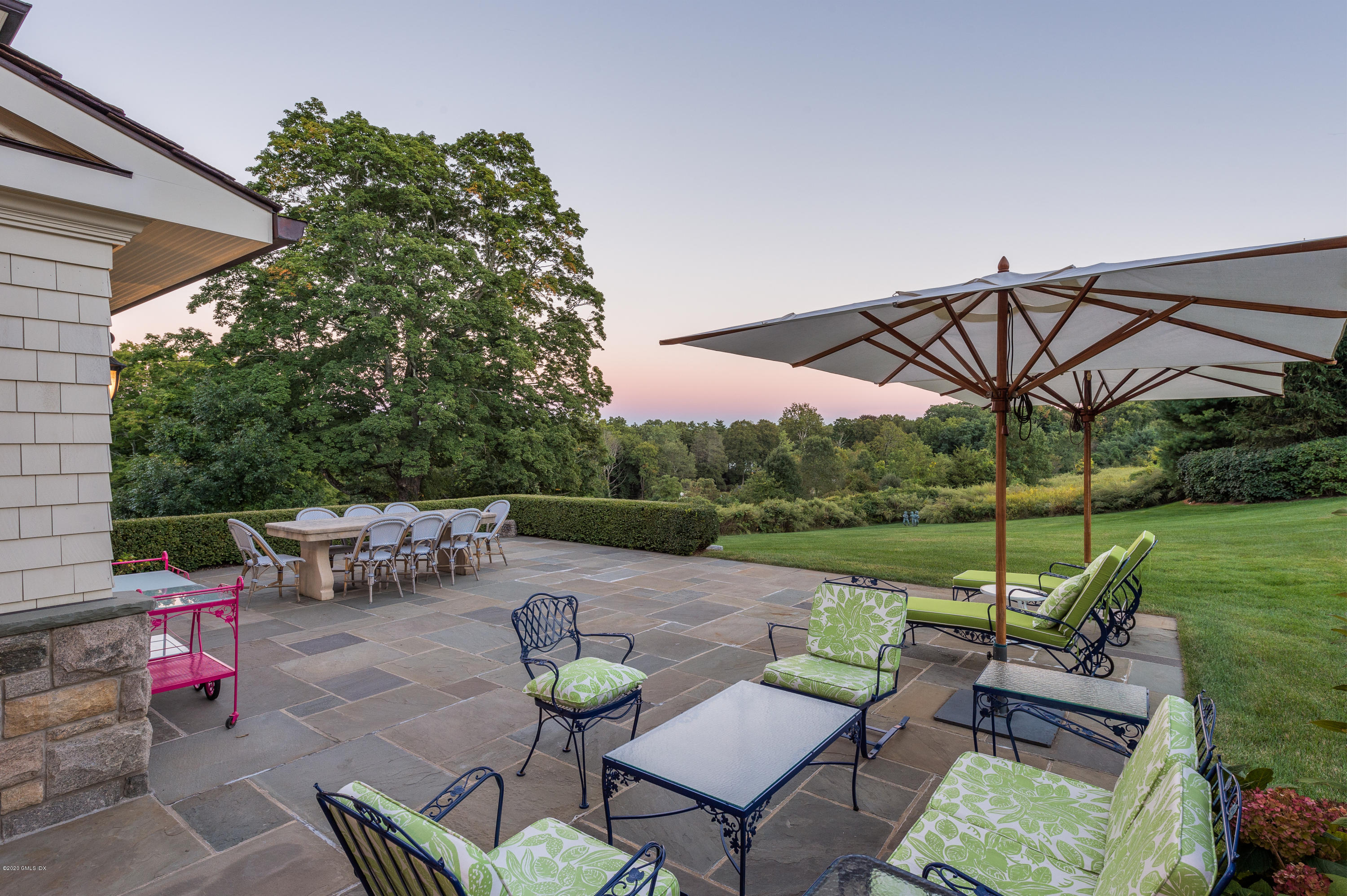 7 Chieftans Road Greenwich, CT 06831 - Photo 31 of 37 a view of a patio with couches table and chairs under an umbrella