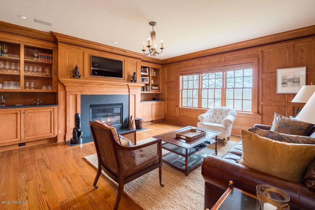 7 Chieftans Road Greenwich, CT 06831 - Photo 9 of 37 a living room with furniture a fireplace and a flat screen tv
