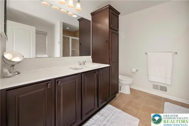 a bathroom with a sink a toilet and a mirror