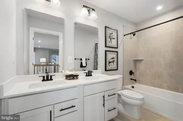 a bathroom with a toilet a sink a mirror a shower and vanity