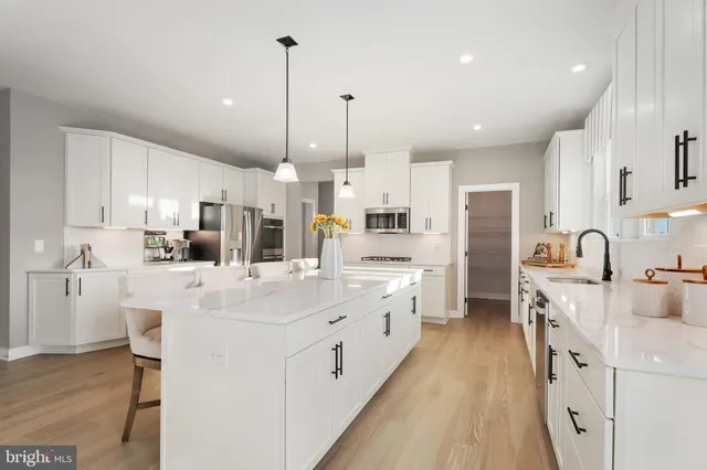 a kitchen with kitchen island white cabinets and stainless steel appliances