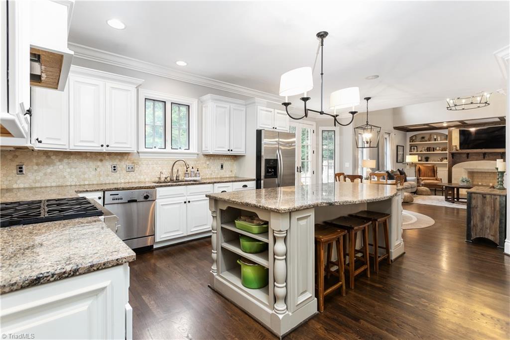 8302 Linville Oaks Drive Oak Ridge, NC 27310 - Photo 13 of 46 Beautiful kitchen with massive island, granite countertops, tile backsplash, gas range and stainless appliances.