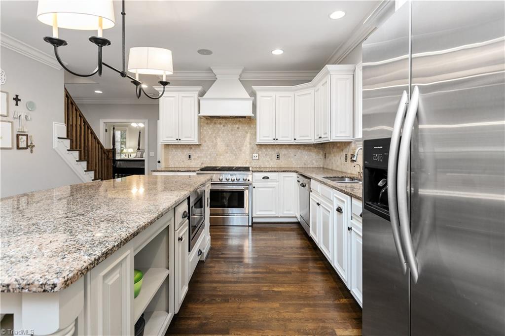 8302 Linville Oaks Drive Oak Ridge, NC 27310 - Photo 14 of 46 Large gas range oven, microwave that is built into the island and open shelving for displaying beautiful cookware.