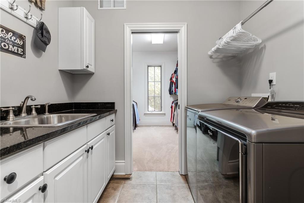 8302 Linville Oaks Drive Oak Ridge, NC 27310 - Photo 24 of 46 Laundry room on the main level with a sink, and storage.