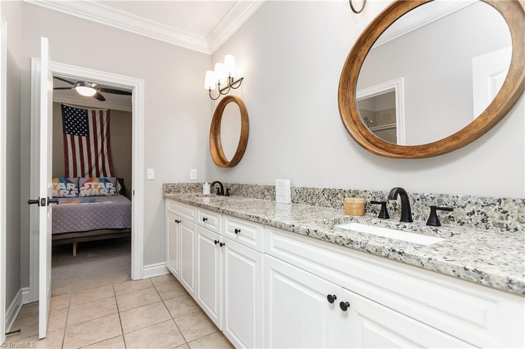 8302 Linville Oaks Drive Oak Ridge, NC 27310 - Photo 26 of 46 Large bath with recent updates and granite tops, double sinks and a separate area with the tub/shower combo and toilet.