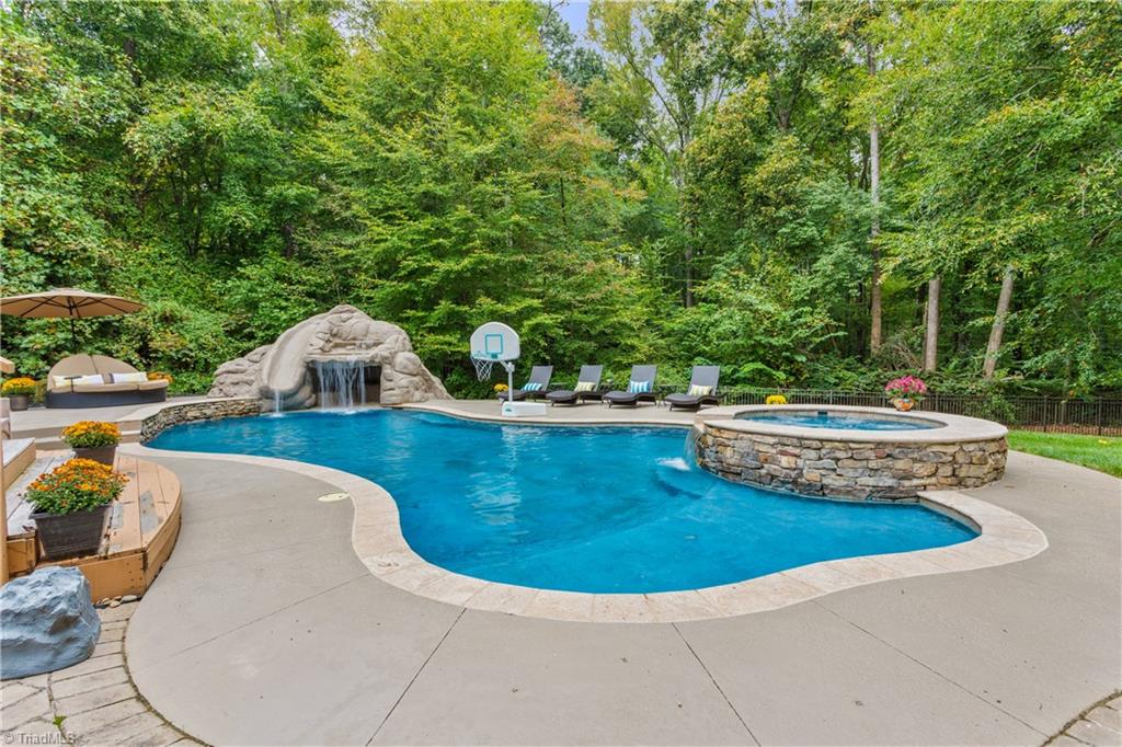 8302 Linville Oaks Drive Oak Ridge, NC 27310 - Photo 9 of 46 The pool has a sun-shelf area, hot tub, waterfall and slide.