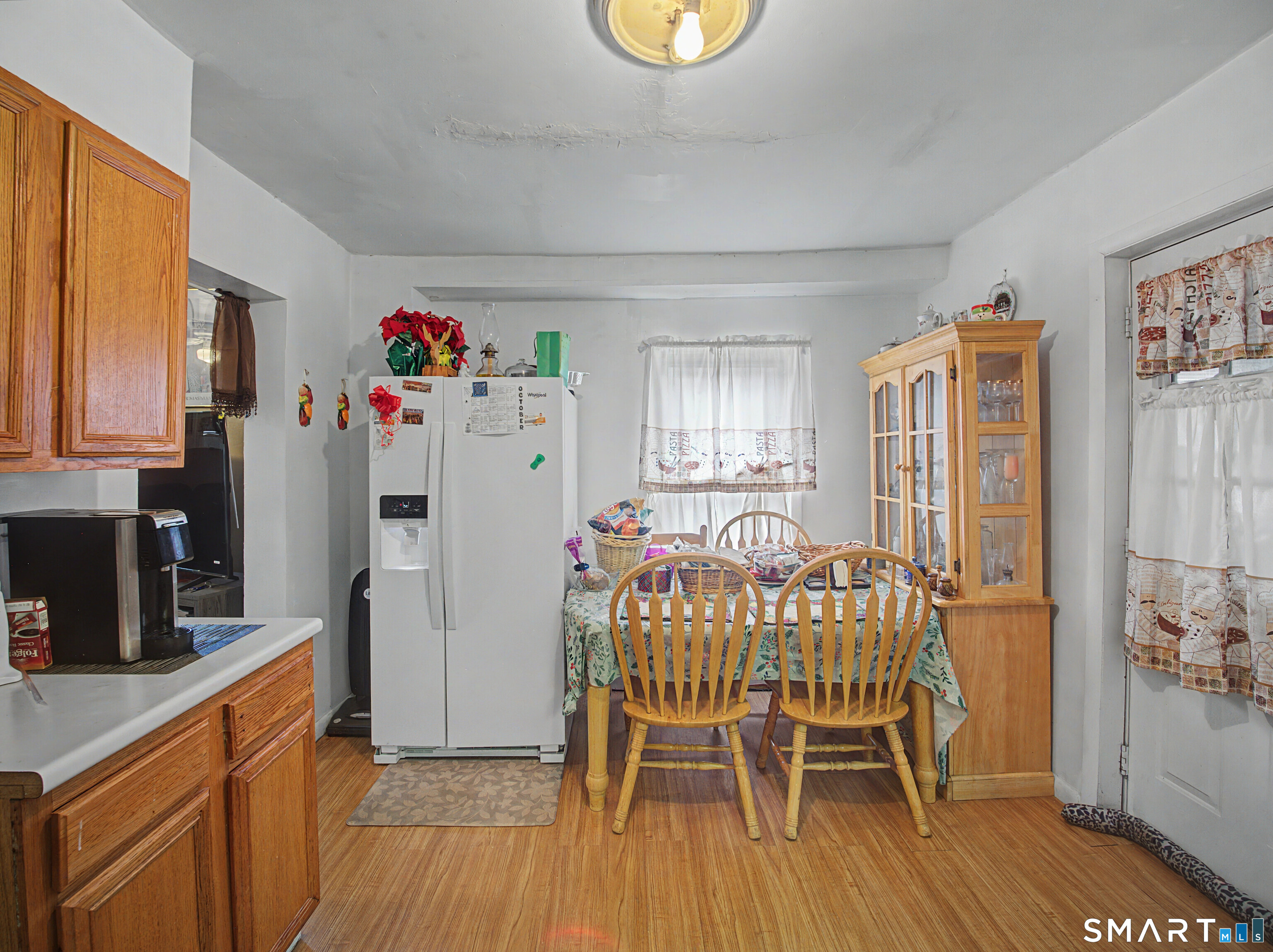 68 Rowan Street Danbury, CT 06810 - Photo 28 of 34 a kitchen with a table chairs refrigerator and microwave