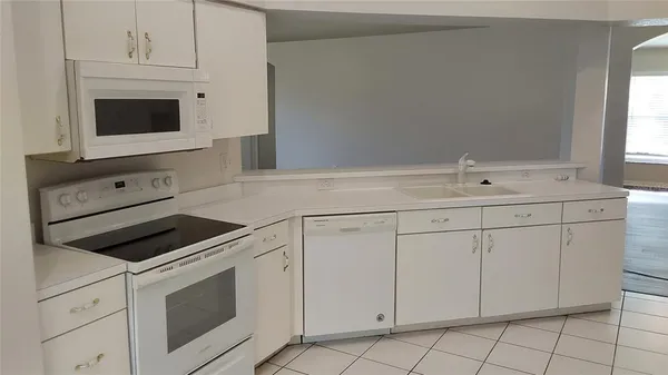 a kitchen with white cabinets and white appliances