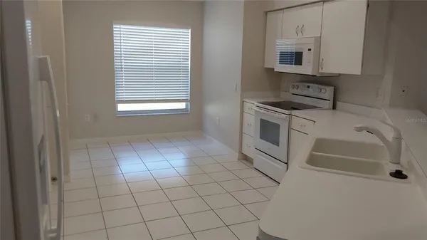 a kitchen with white cabinets a stove top oven and sink