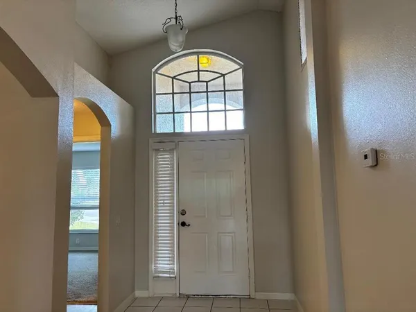 an empty room with windows and chandelier