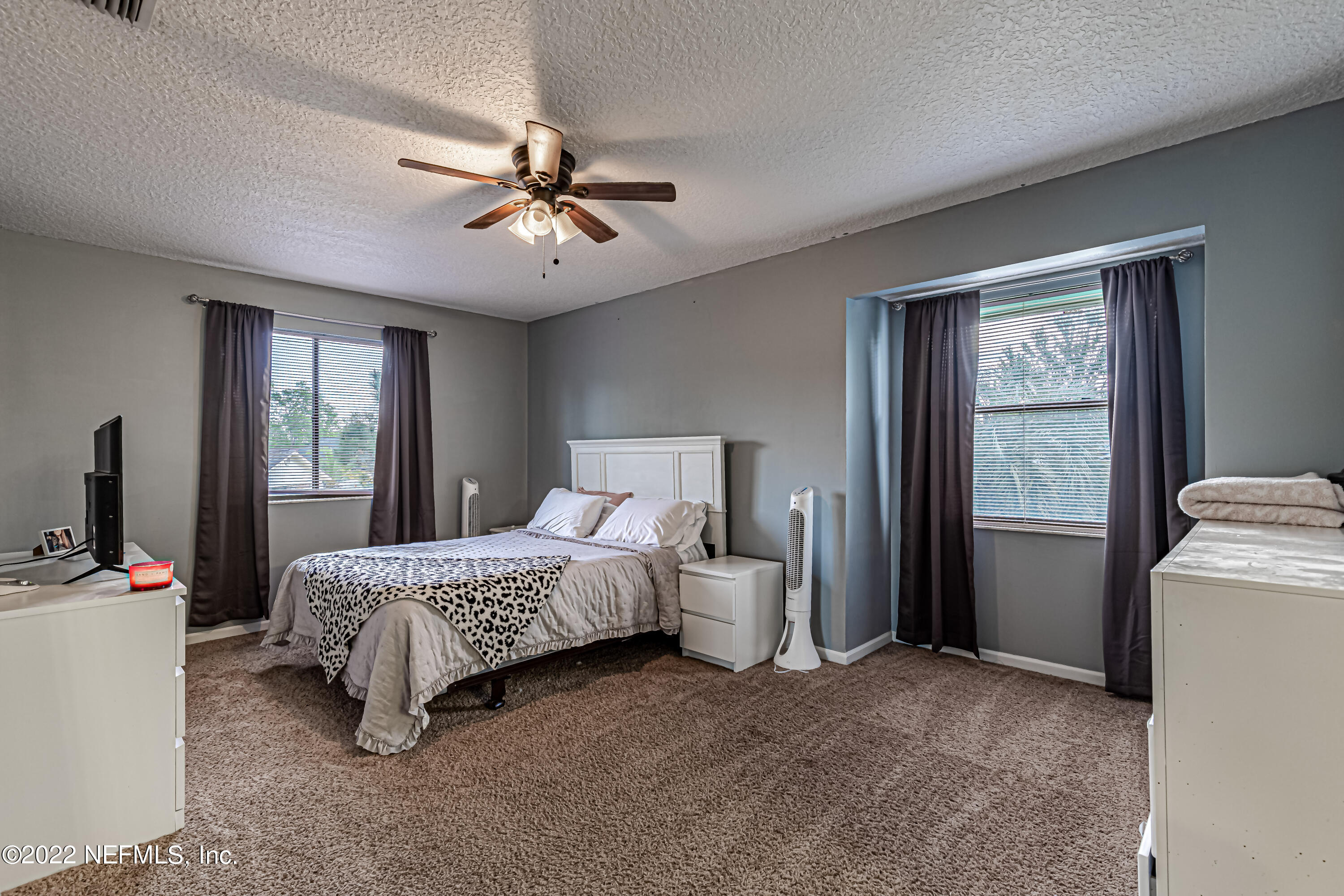 554 George Taylor Street Orange Park, FL 32073 - Photo 28 of 40 a bedroom with a bed and a chandelier