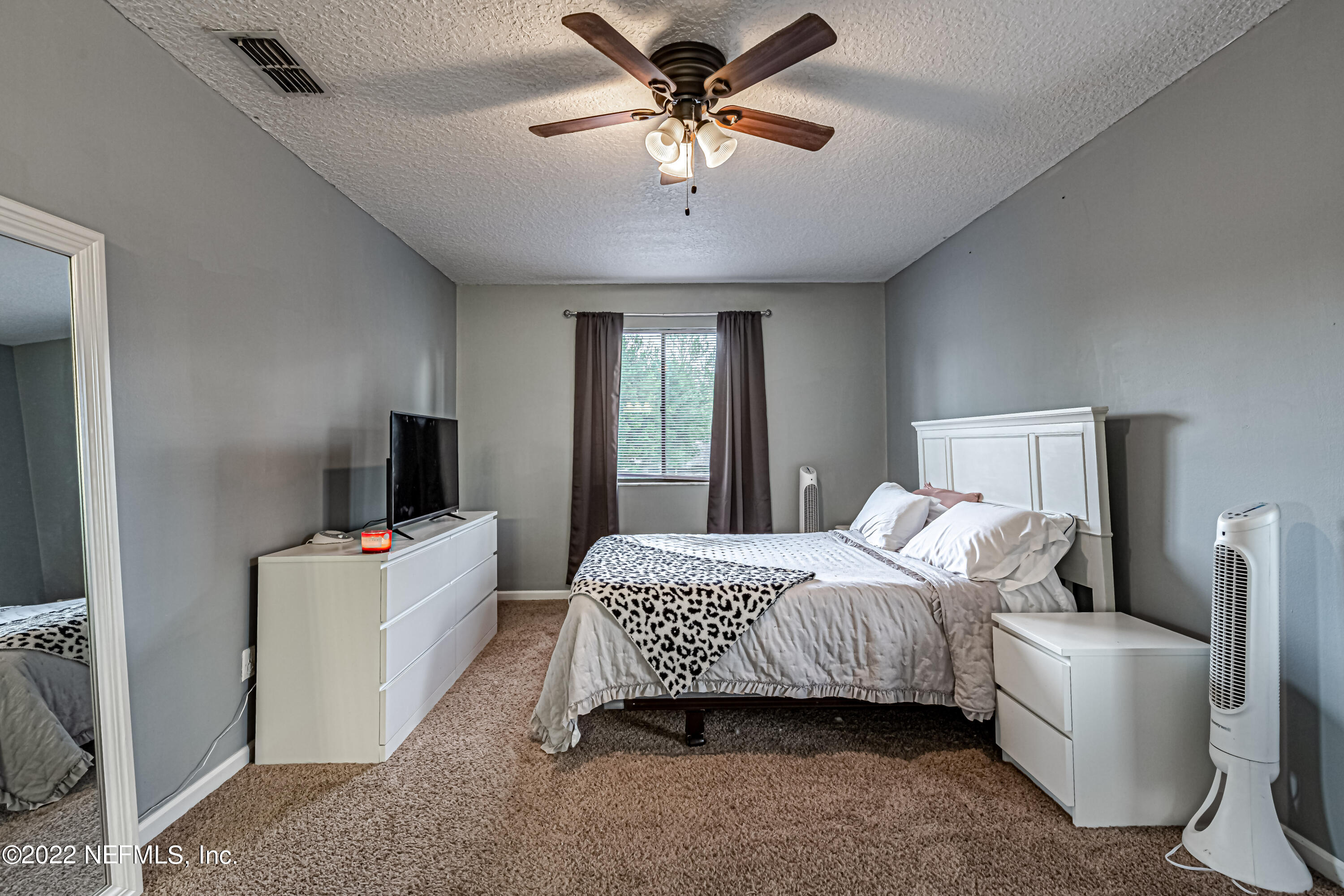 554 George Taylor Street Orange Park, FL 32073 - Photo 31 of 40 a bedroom with a bed and a chandelier
