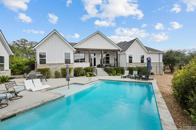 a view of a patio with table and chairs potted plants with wooden floor and fence