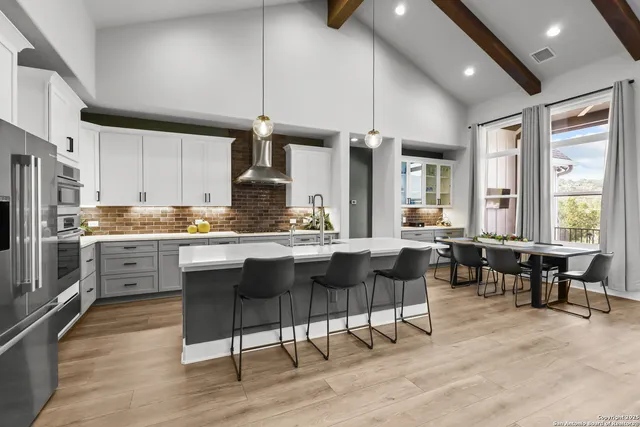 a kitchen with refrigerator cabinets dining table and chairs