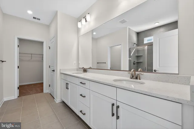 a bathroom with double sink and a mirror