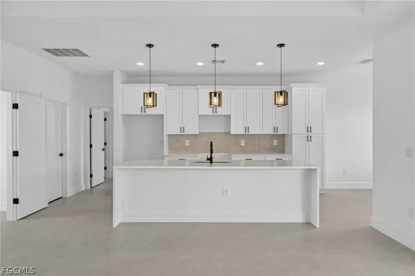 a large kitchen with stainless steel appliances granite countertop a sink and a refrigerator