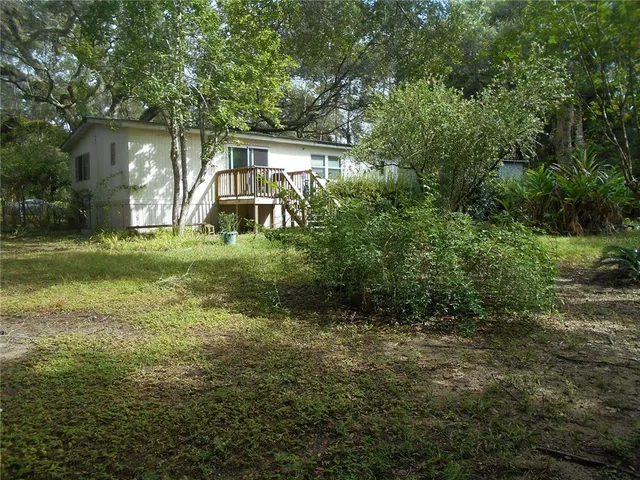a backyard of a house with plants and lake view