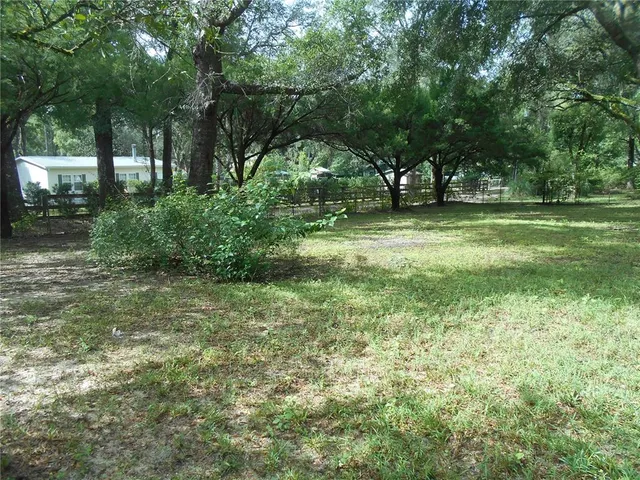 a view of a backyard of the house with a patio