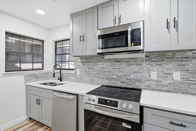 a kitchen with stainless steel appliances granite countertop a sink stove and microwave