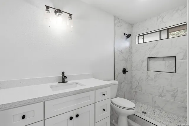 a view of empty room with wooden floor and ceiling fan