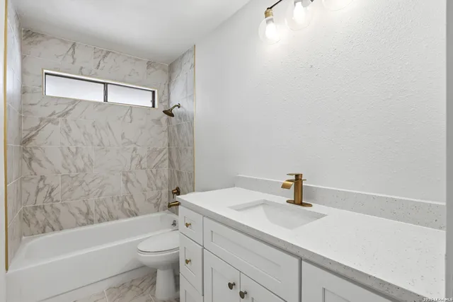 an empty room with a window and a ceiling fan