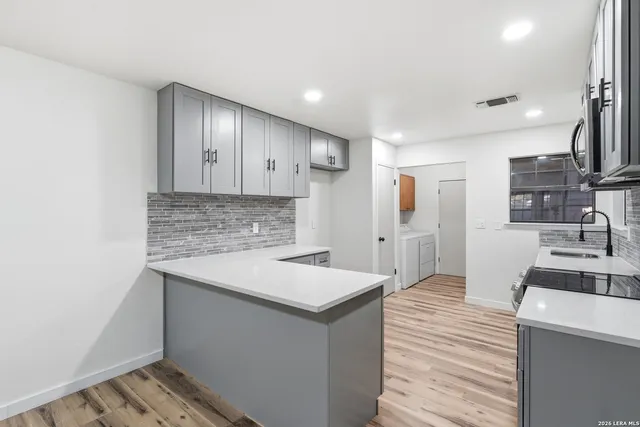 a kitchen with a sink stove and cabinets