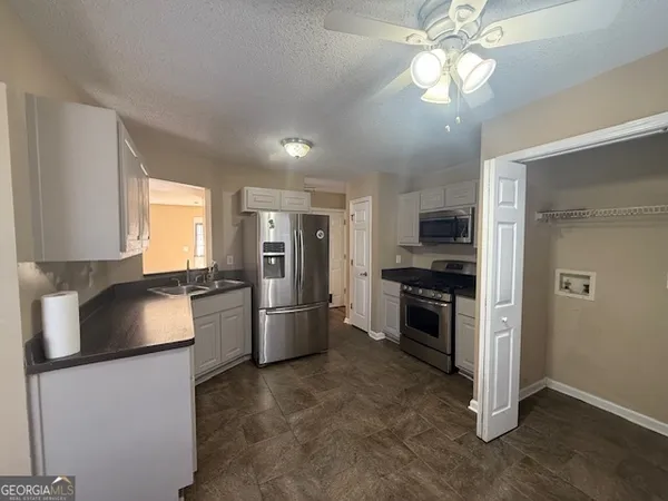 a kitchen with a refrigerator and a stove top oven