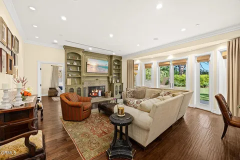 a living room with fireplace furniture and a large window