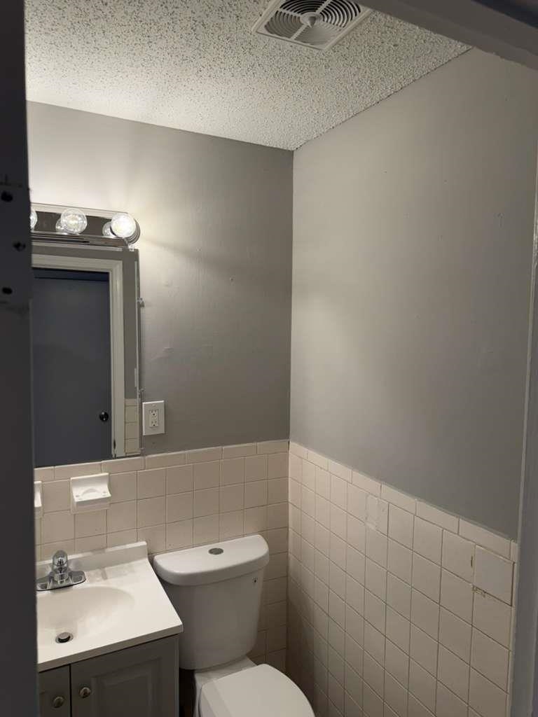 1010 University Street Memphis, TN 38107 - Photo 4 of 17 a bathroom with a toilet a sink and mirror