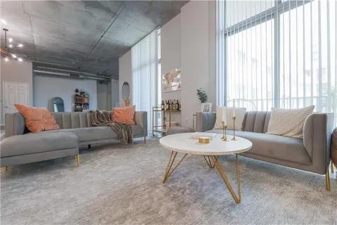 a living room with furniture a table and a large window