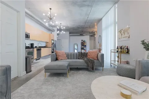 a living room with furniture a chandelier and a dining room