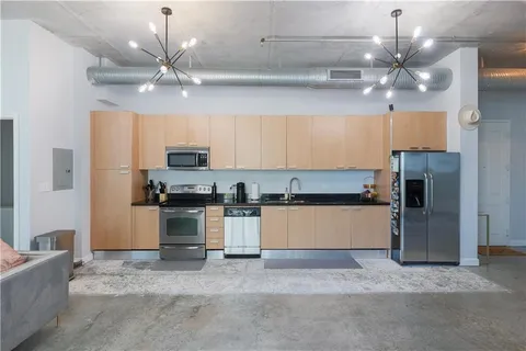 a kitchen with kitchen island stainless steel appliances a stove refrigerator and microwave