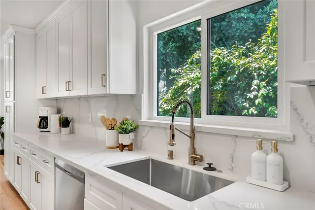 a kitchen with stainless steel appliances granite countertop a sink a stove and a wooden floors