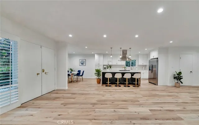a large kitchen with stainless steel appliances granite countertop a stove and a view of living room