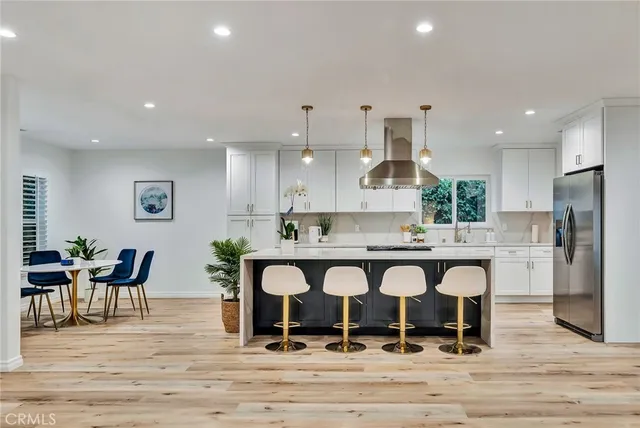 an open kitchen with kitchen island and center island hardwood floor and a sink