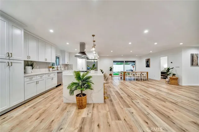 a dining room with furniture potted plants and wooden floor