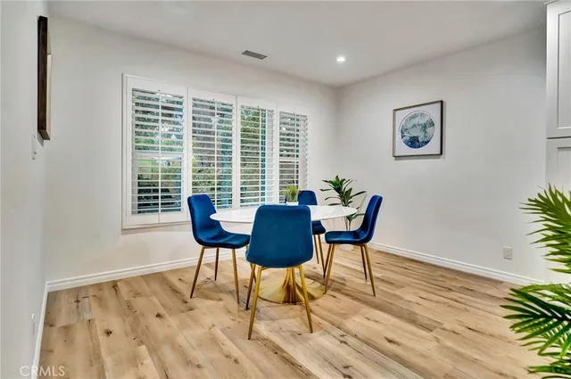 a living room with furniture a potted plant and kitchen view